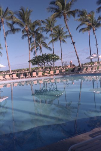 Pool with lounge chairs reflected