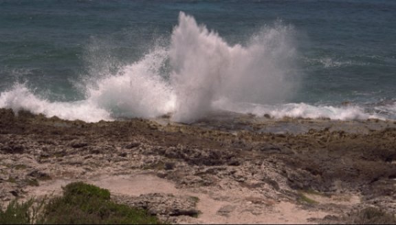Water spraying through rocky beach